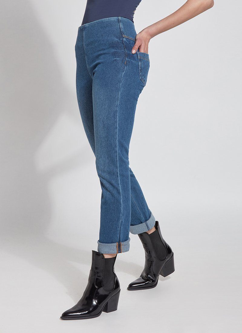 color=Mid Wash, angled front view, plus size boyfriend cut denim leggings with comfort waistband to smooth and slim