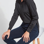 color=Black, seated side view, slim fit women’s button up shirt with curved hem, made with wrinkle resistant microfiber