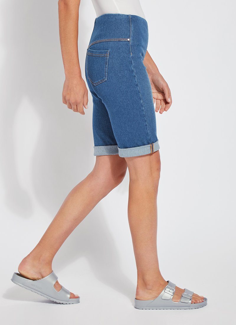 color=Mid Wash, side view, women's denim jean short, smoothing comfort waistband, body hugging in hips and looser across thigh